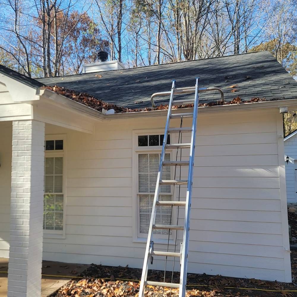 A ladder is sitting on the side of a white house.