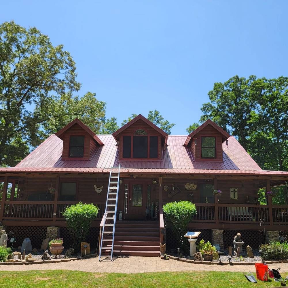 A large house with a red roof and a ladder in front of it
