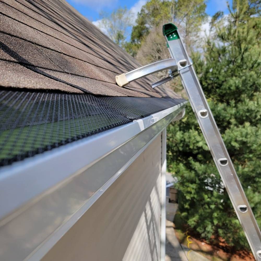 A ladder is attached to a gutter on the side of a house.