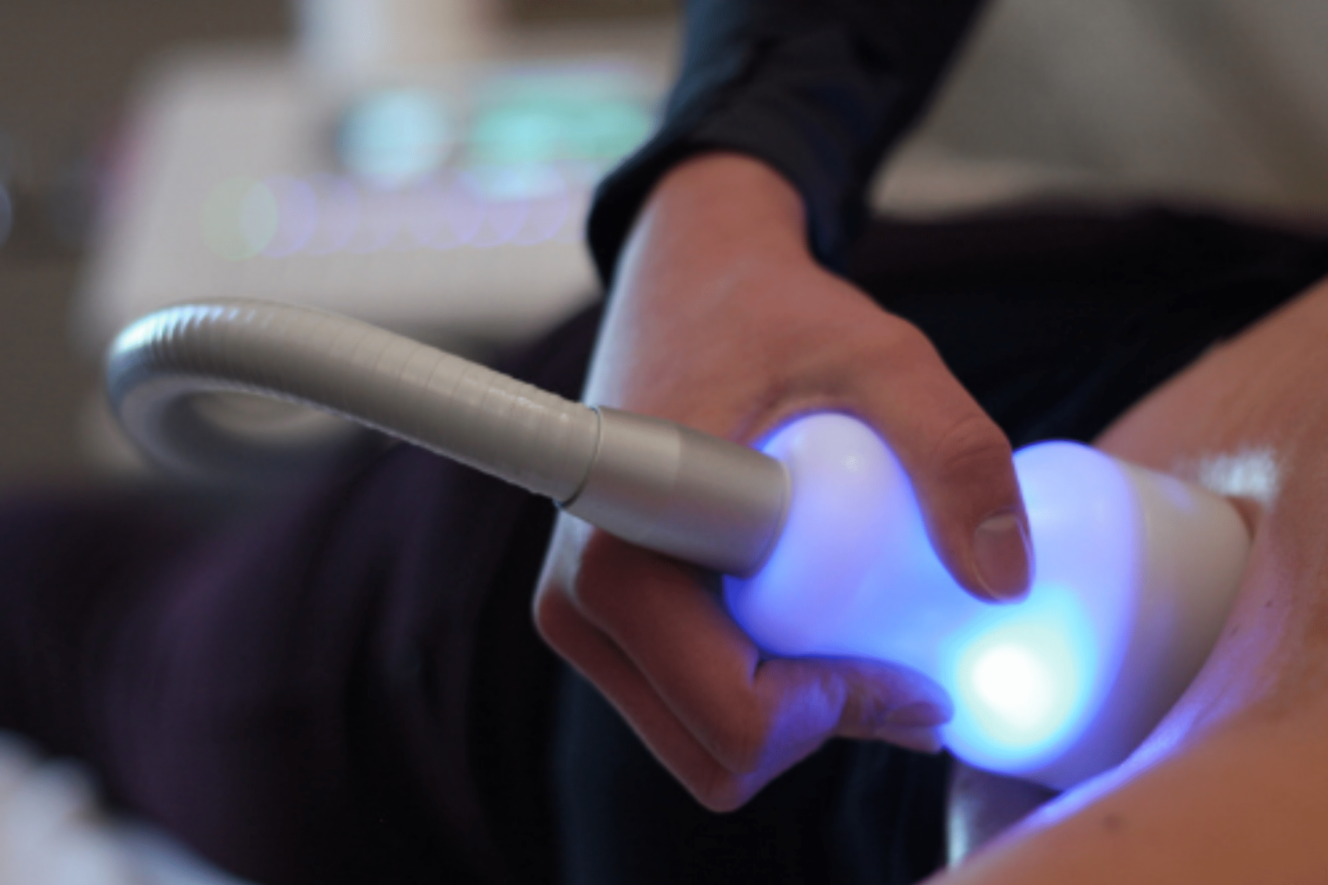 A close up of a person using a device with a blue light on it