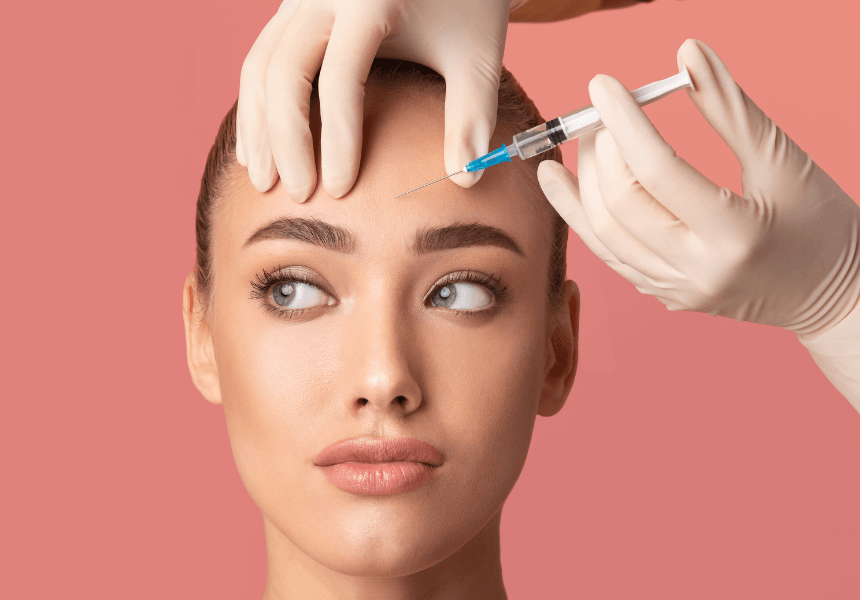 A woman is getting a botox injection in her forehead.