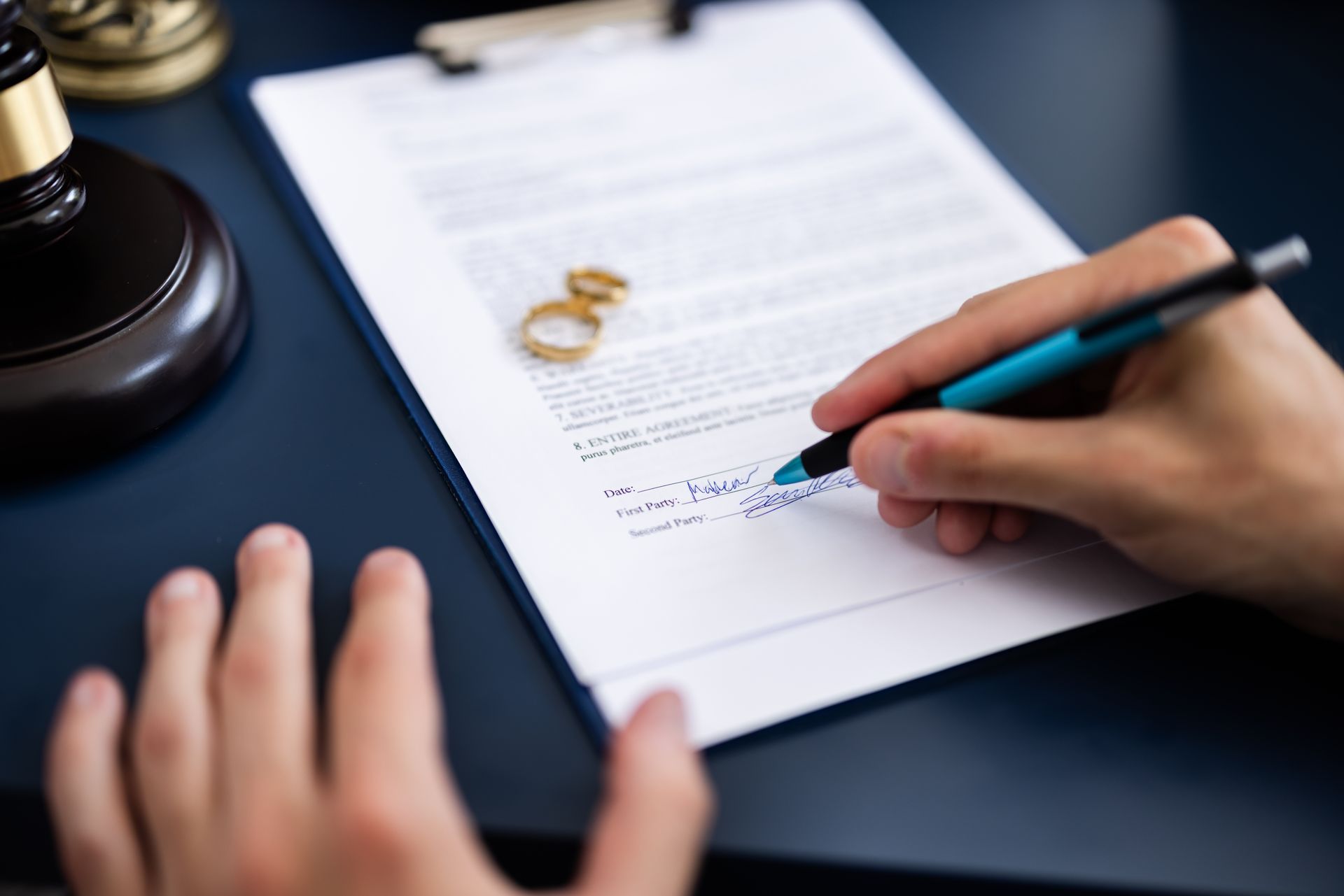 A person is writing on a piece of paper with a pen.