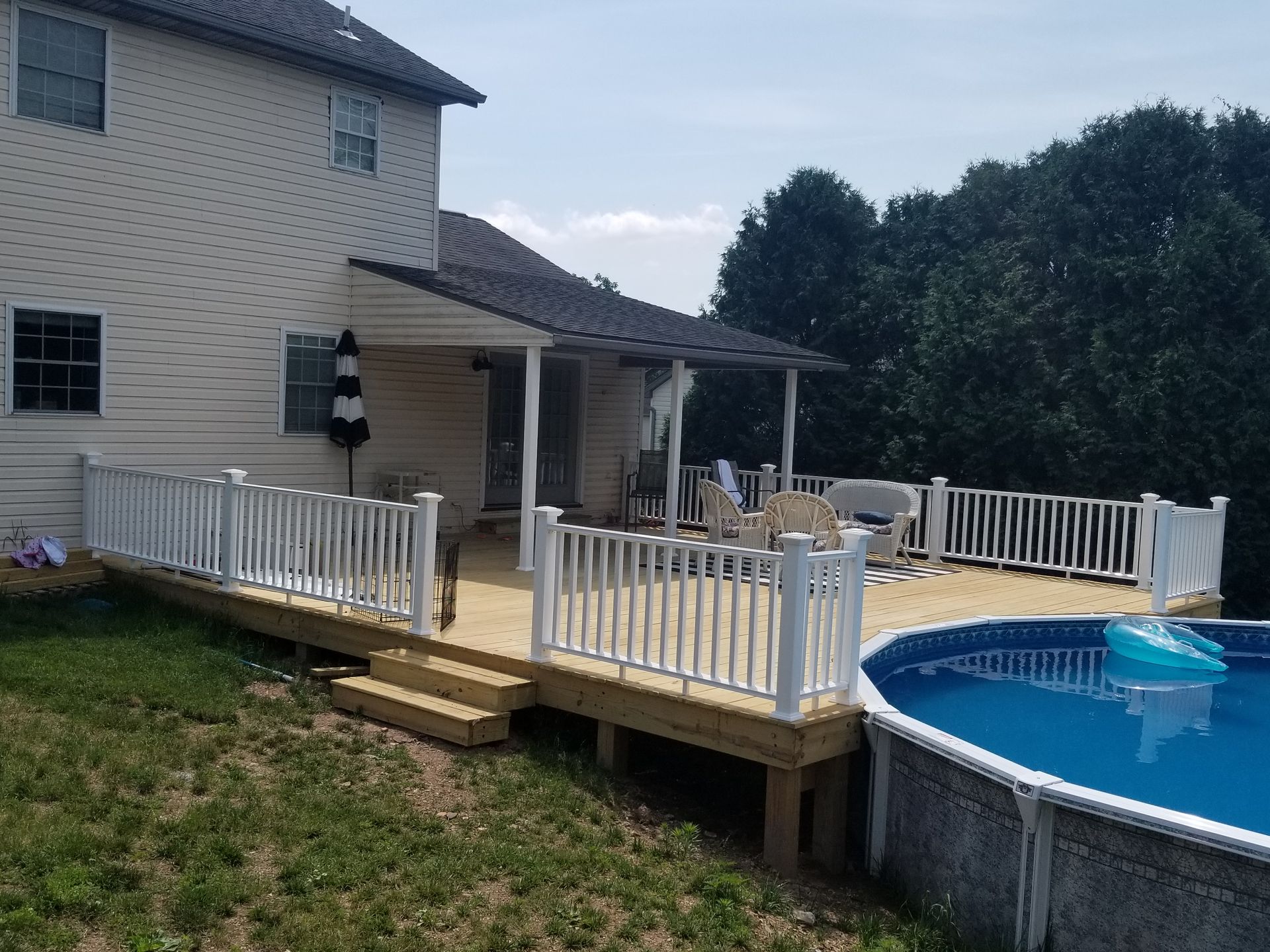 A house with a wooden deck and stairs leading to it A house with a wooden deck and stairs leading to it