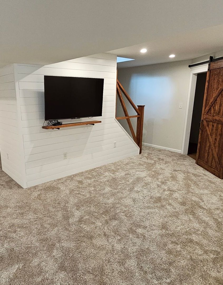 An empty living room with a ceiling fan and hardwood floors. An empty living room with a ceiling fan and hardwood floors.