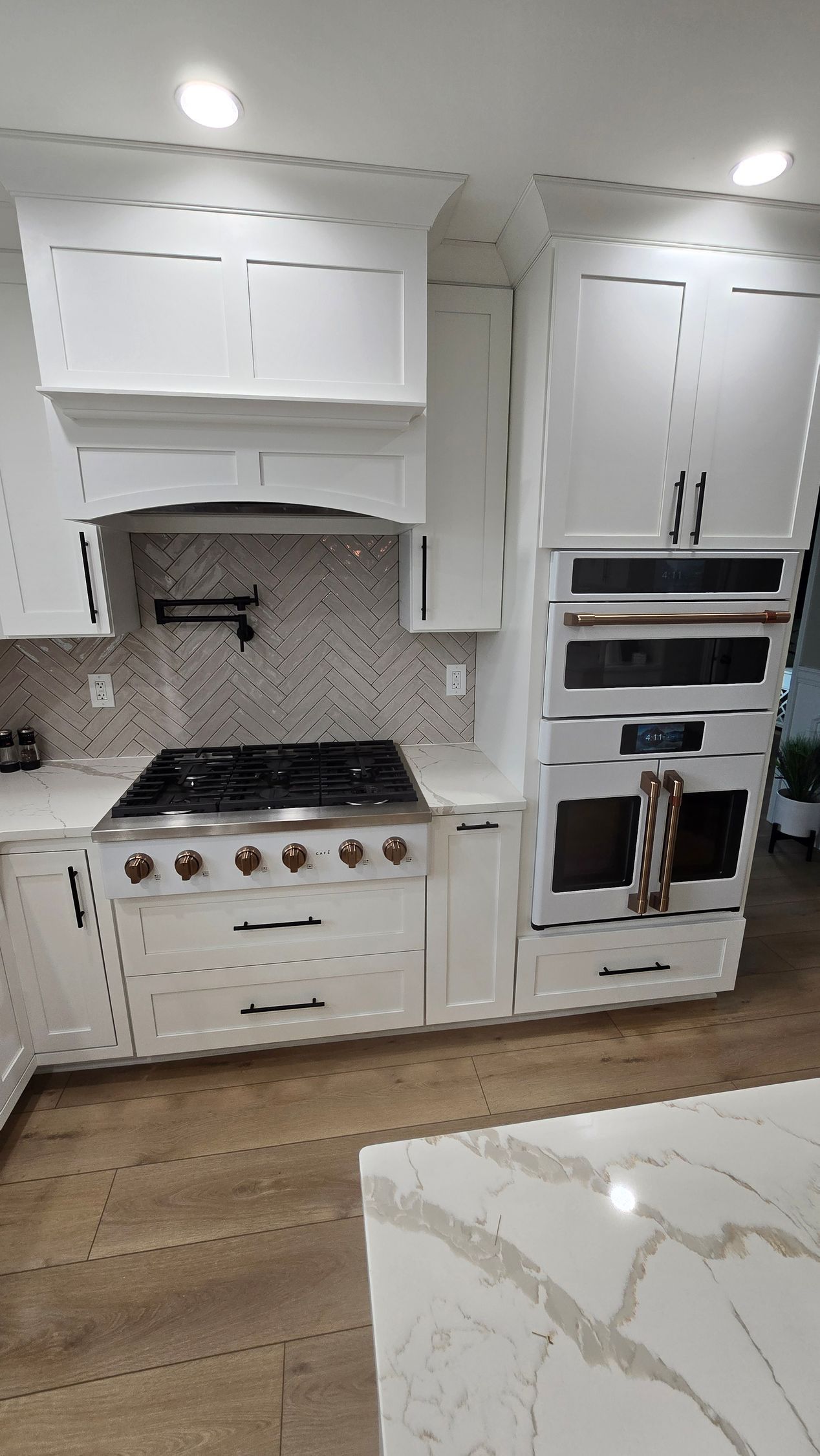 A kitchen with white cabinets and a wooden table A kitchen with white cabinets and a wooden table