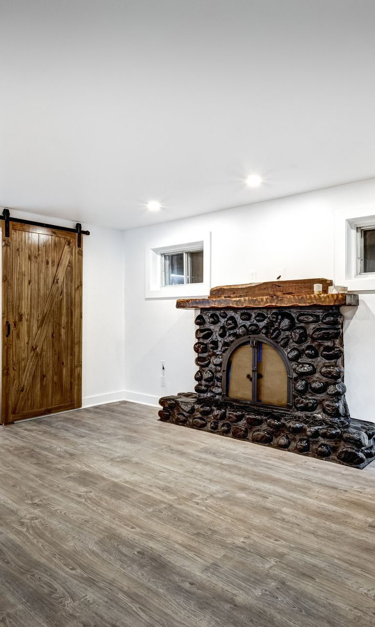 There is a stone fireplace in the middle of the room. There is a stone fireplace in the middle of the room.