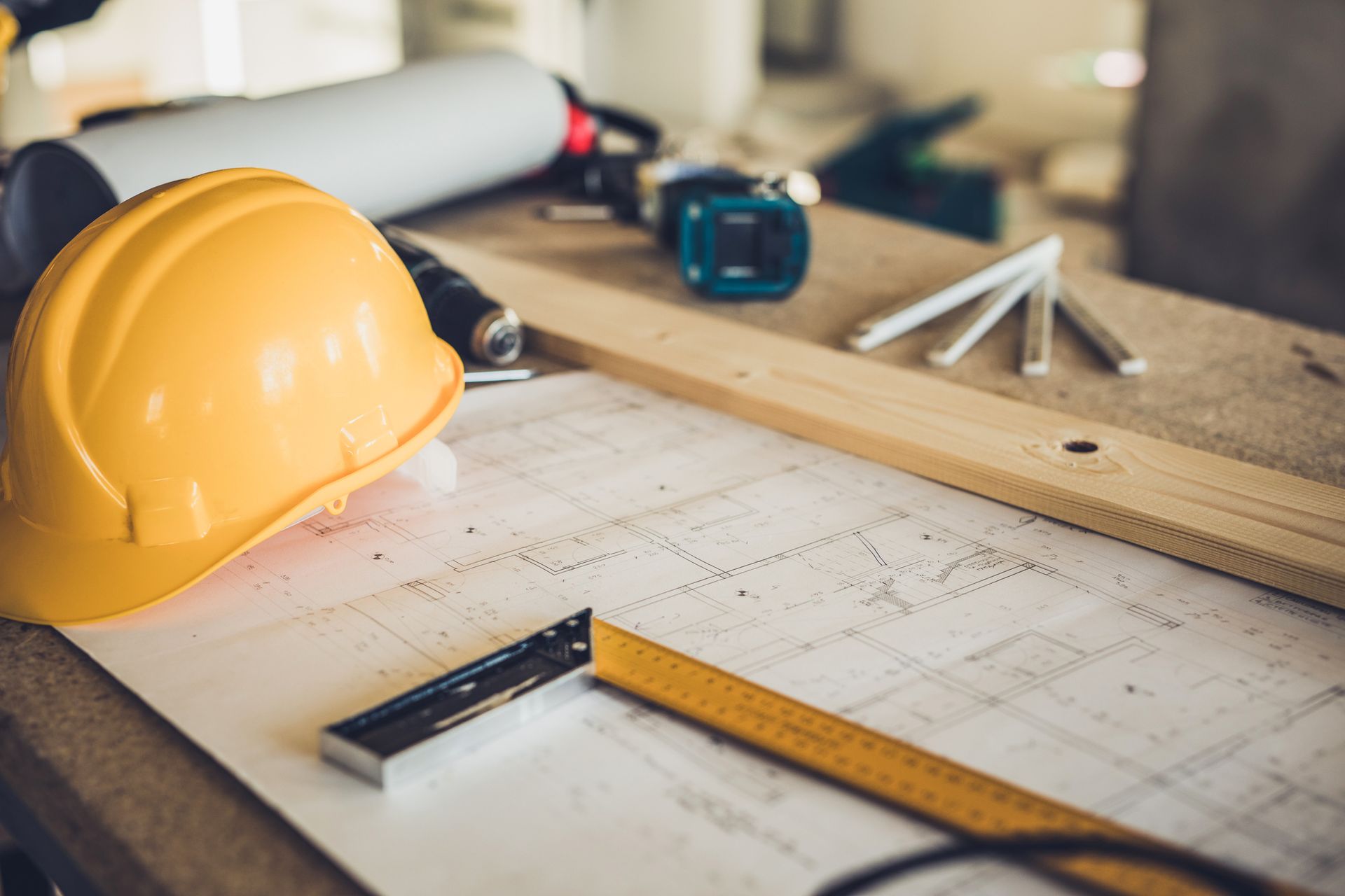 A hard hat is sitting on top of a blueprint on a table.