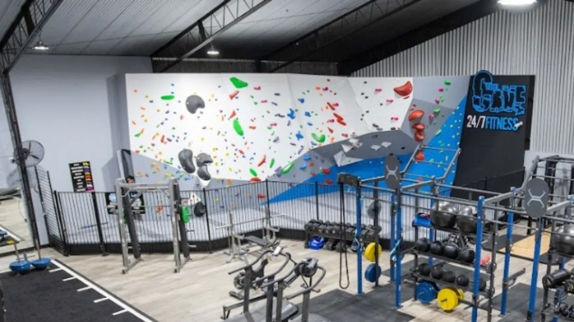 There is a climbing wall in the middle of the gym.