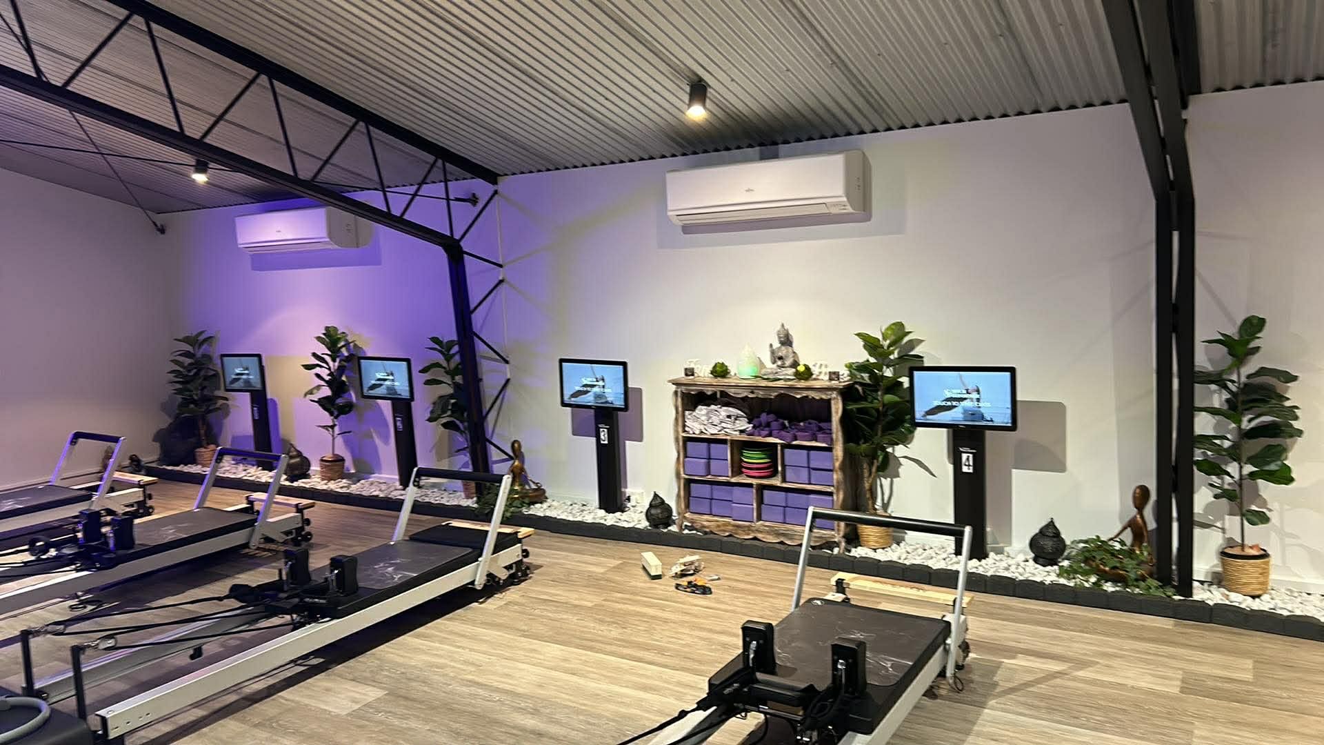 A woman is doing a handstand on a pilates machine.
