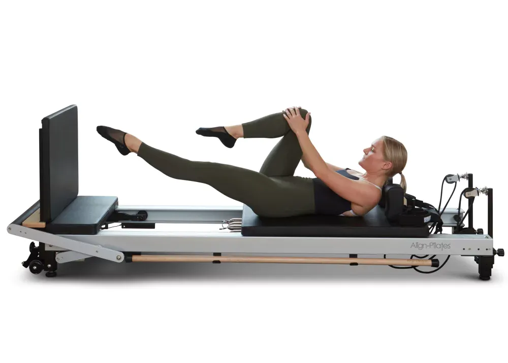 A woman is doing a handstand on a pilates machine.