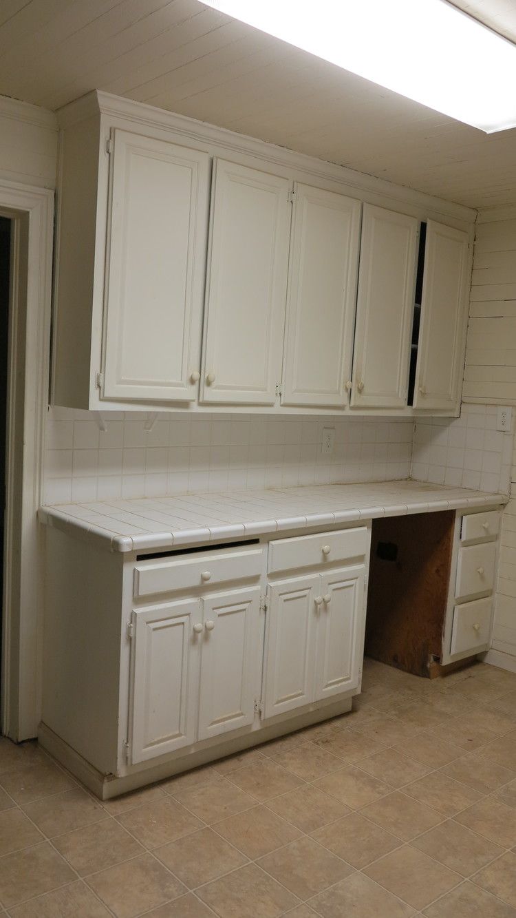 a kitchen with white cabinets and a counter top