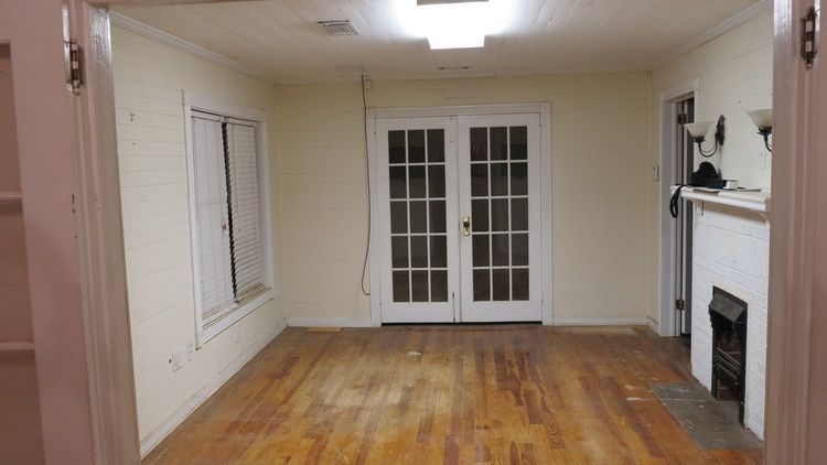 an empty living room with hardwood floors and a fireplace