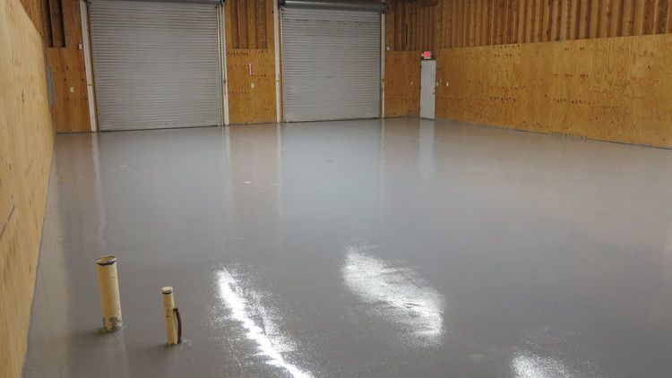 a large empty warehouse with a concrete floor and wooden walls