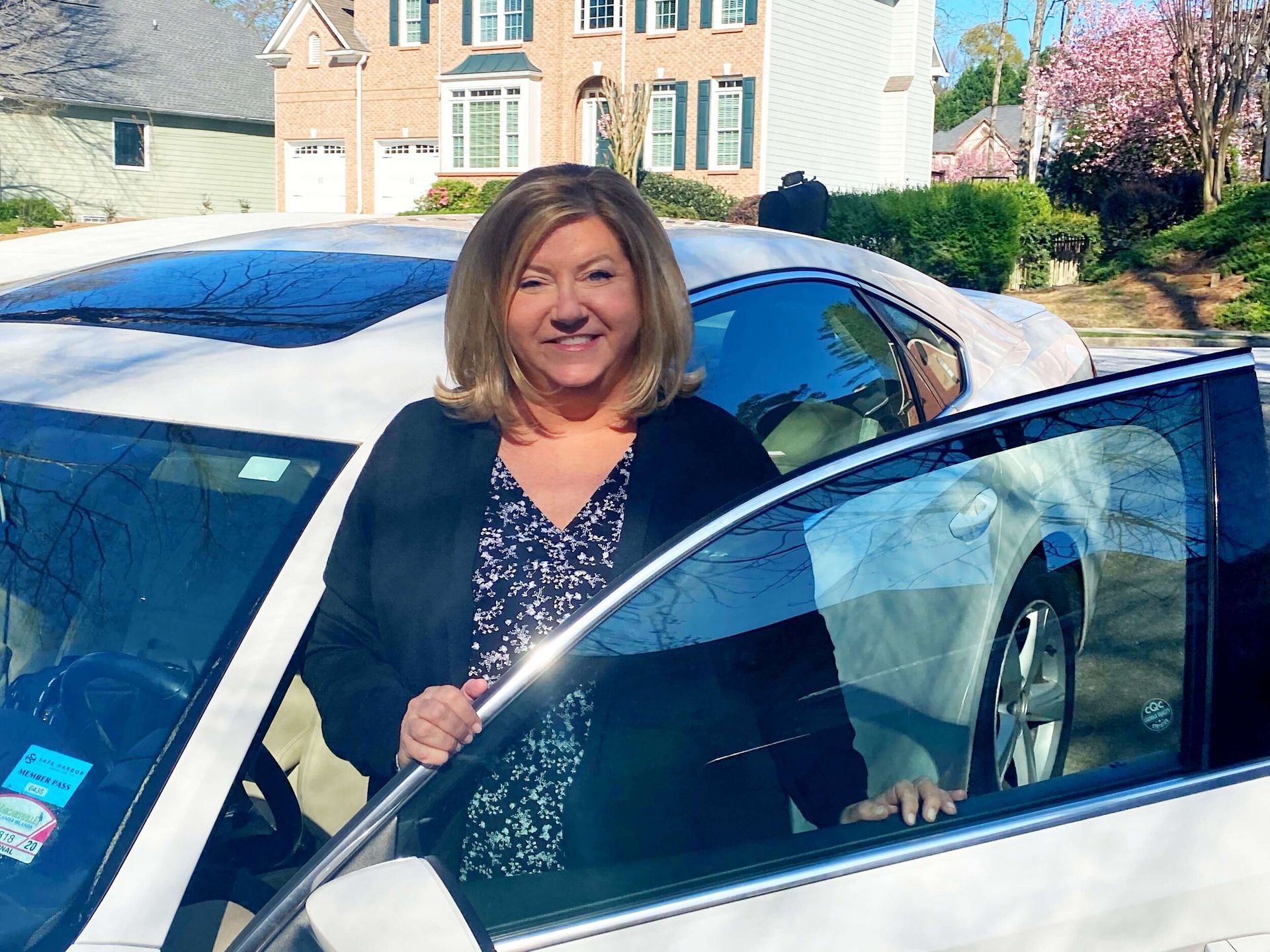 a woman is standing in front of a white car