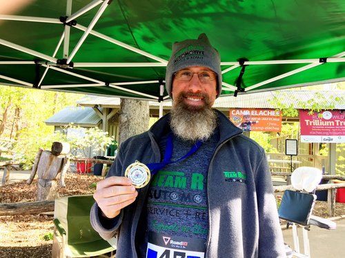 a man with a beard is holding a medal in his hand .