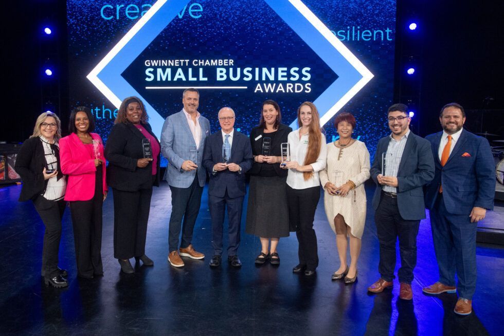 a group of people are posing for a picture on a stage at the small business awards