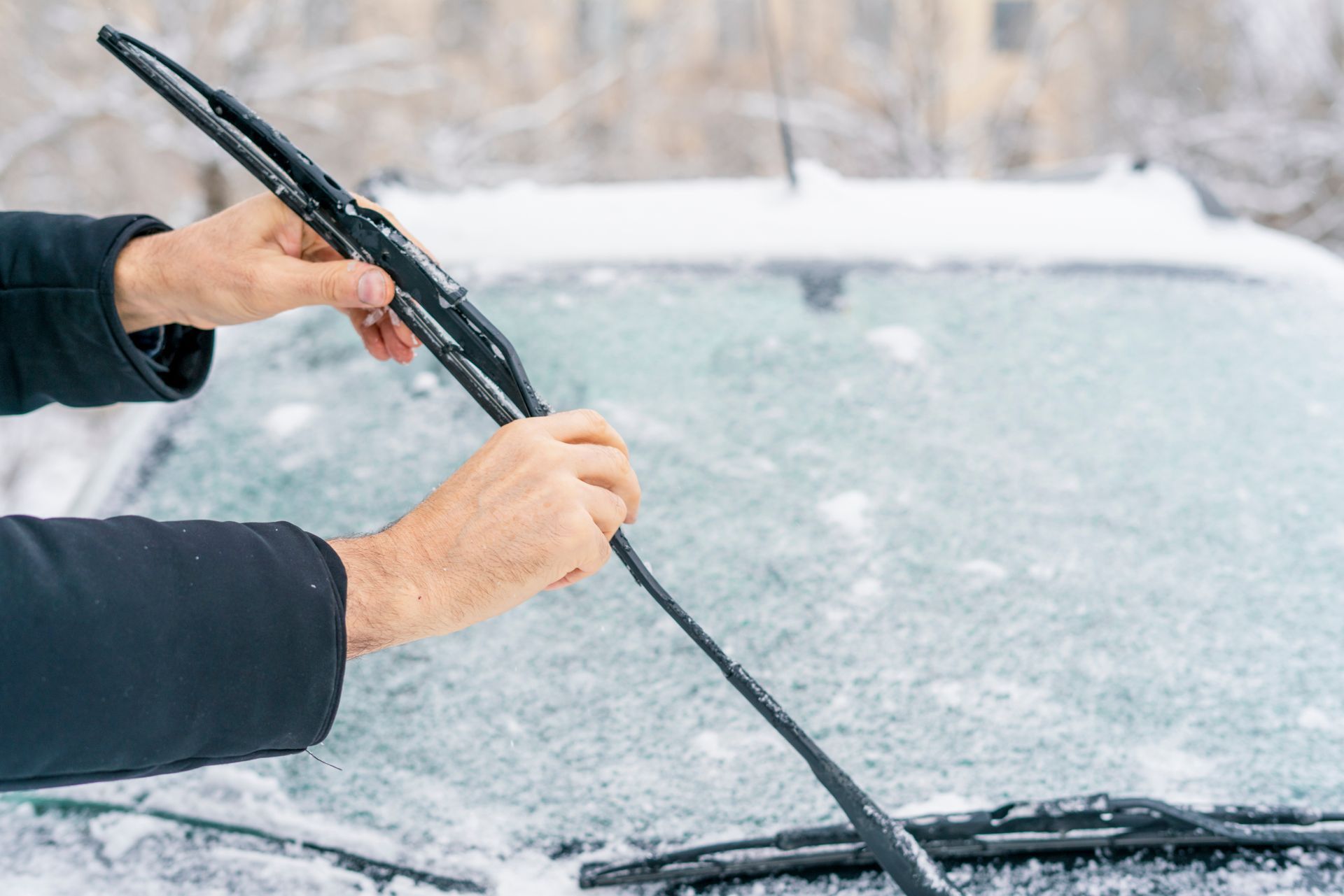 a person is cleaning the windshield of a car with a wiper blade