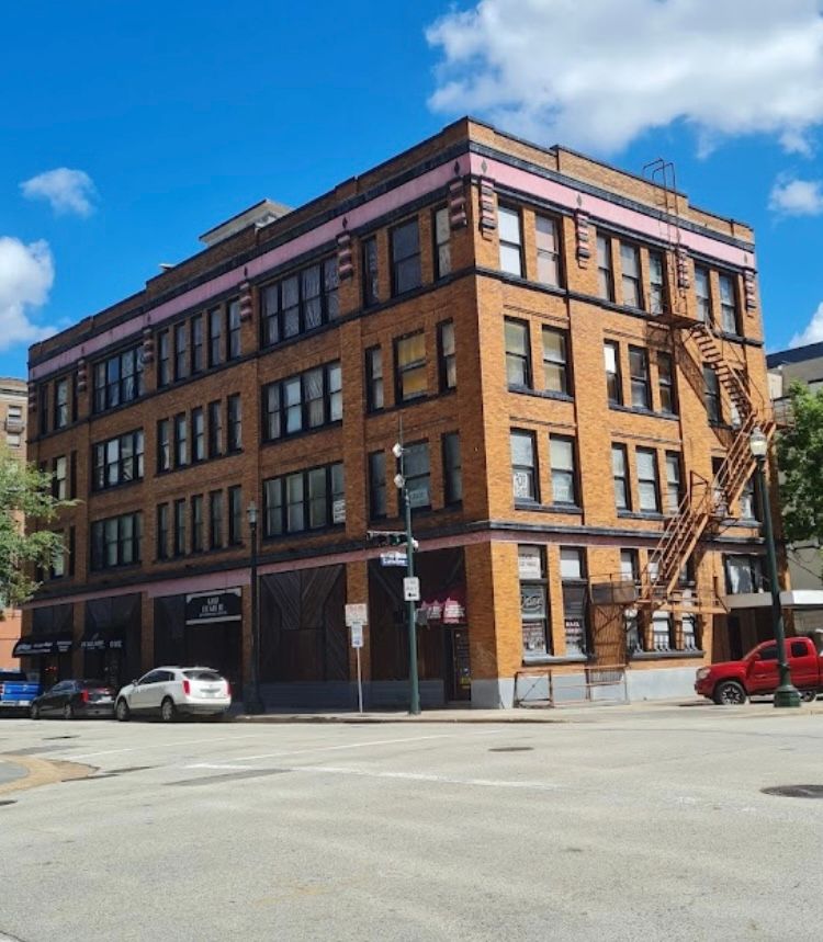 A large brick building with a red truck parked in front of it