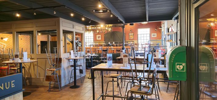 Un restaurant rempli de tables et de chaises et d'une boîte verte avec un cœur dessus.