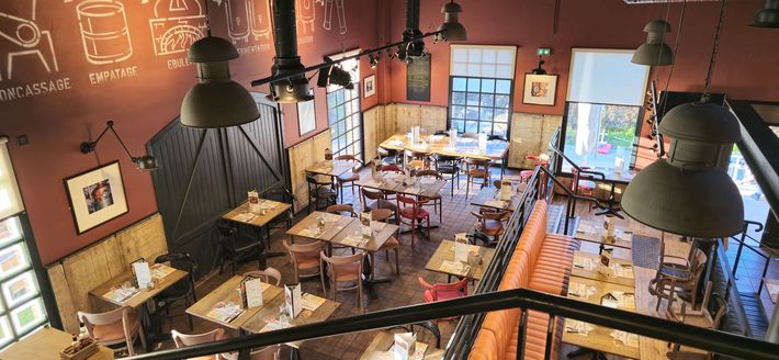 Une vue aérienne d'un restaurant rempli de tables et de chaises.