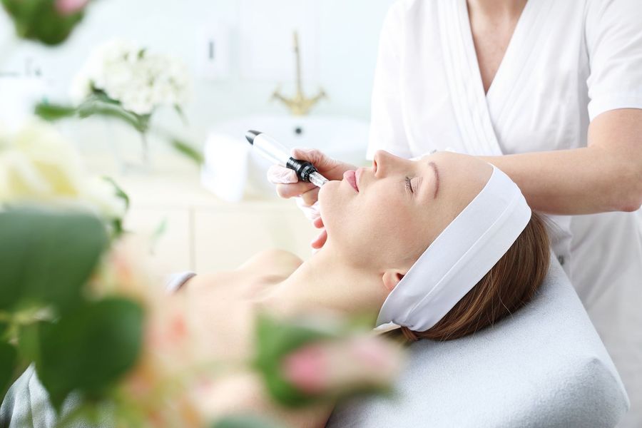 Une femme reçoit un soin du visage dans un salon de beauté.