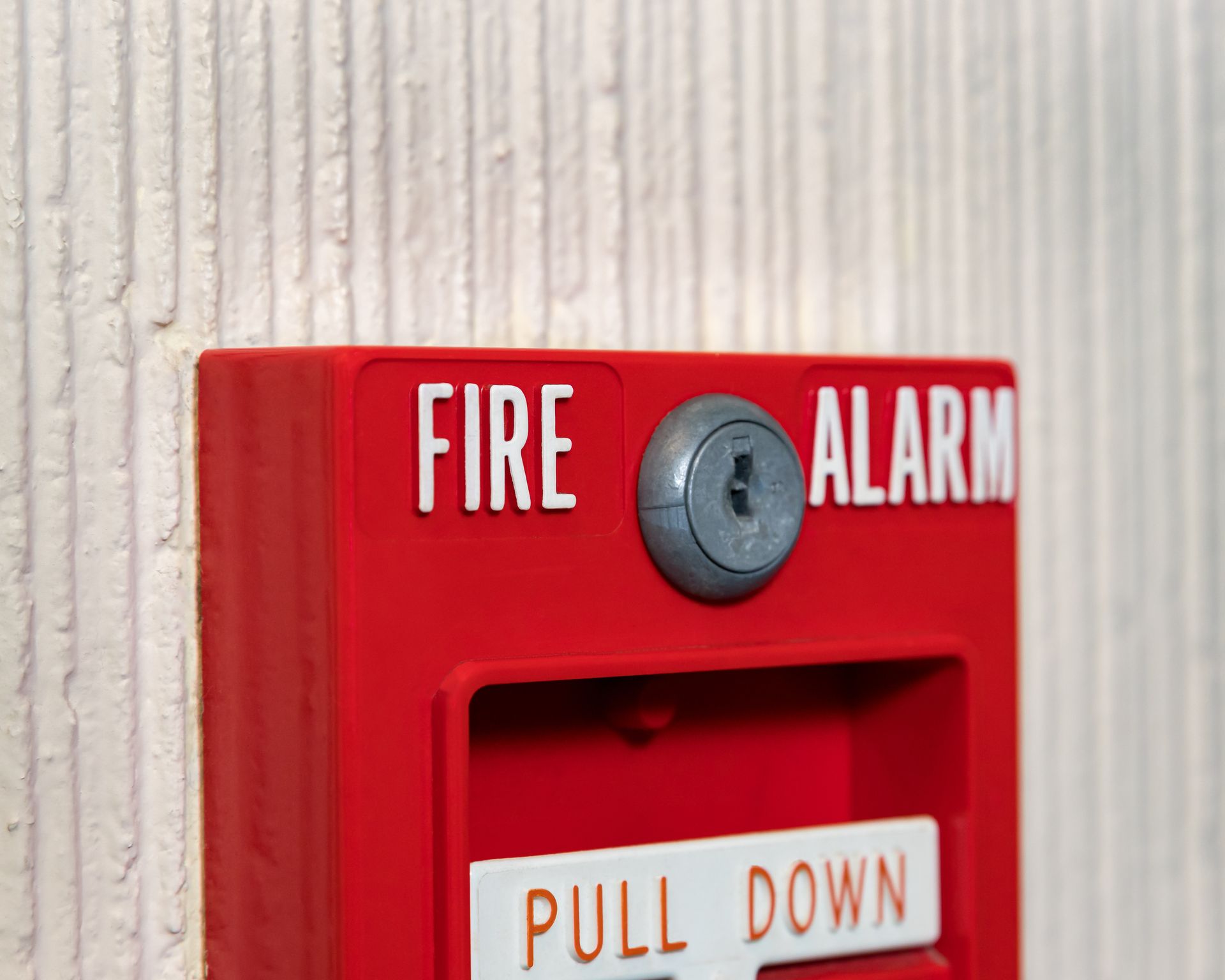 Red fire alarm box mounted on a textured white wall; Red fire alarm box mounted on a textured white wall;