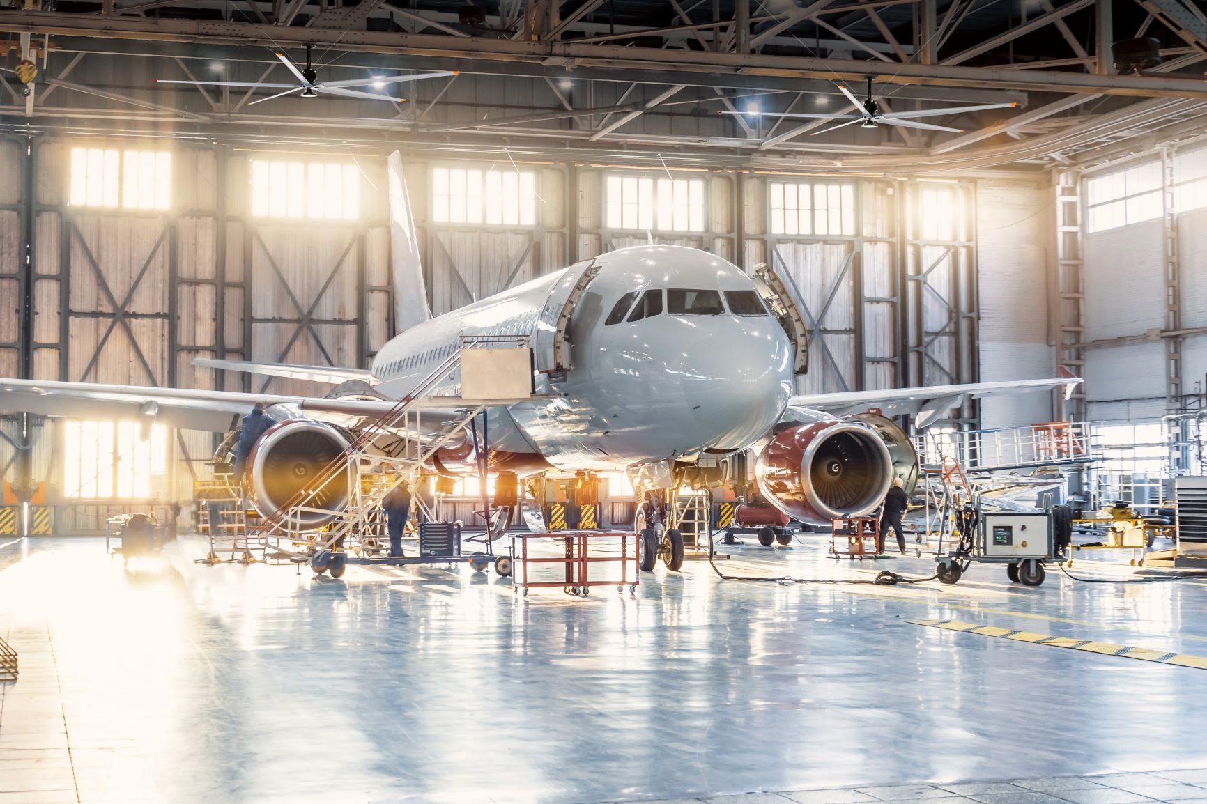An airplane is being repaired in a hangar.