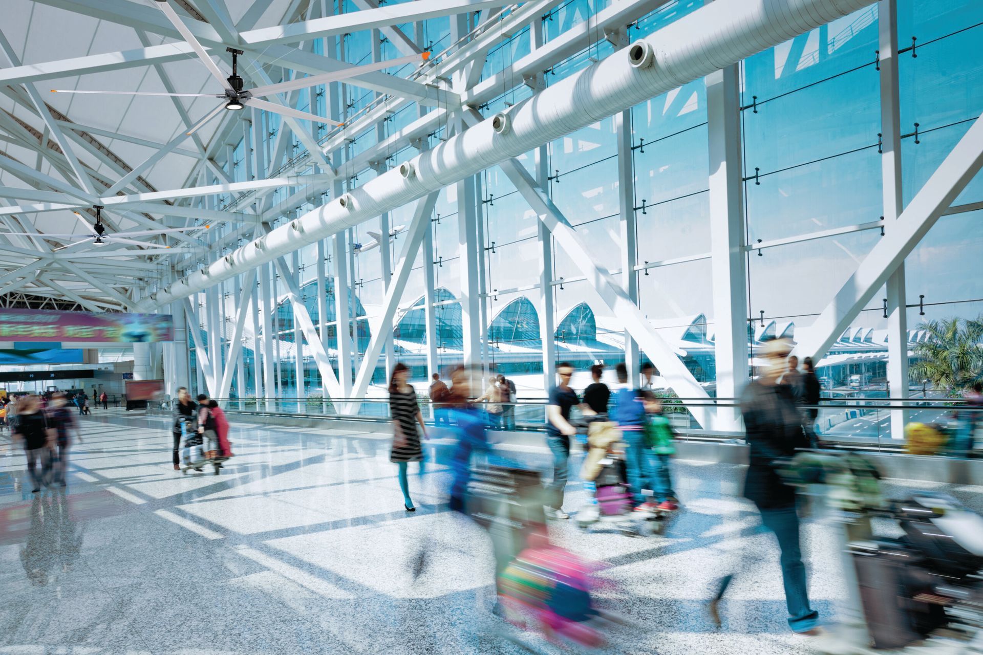 A blurry picture of people walking through an airport terminal.
