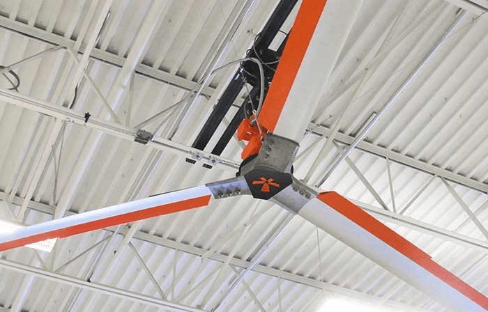 A large fan is hanging from the ceiling of a building