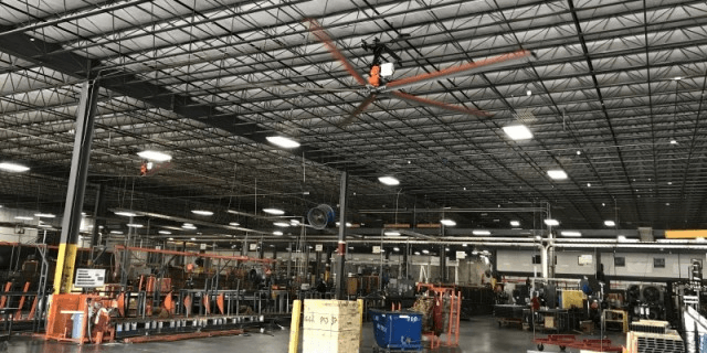 A large warehouse with a large fan hanging from the ceiling.