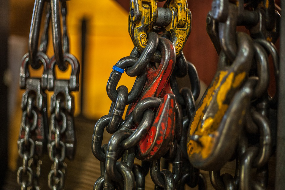 A close up of a bunch of chains hanging from a hook.