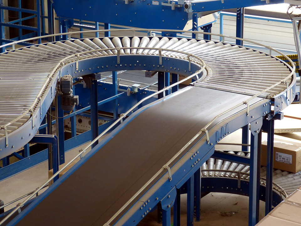 A conveyor belt in a warehouse with boxes on it