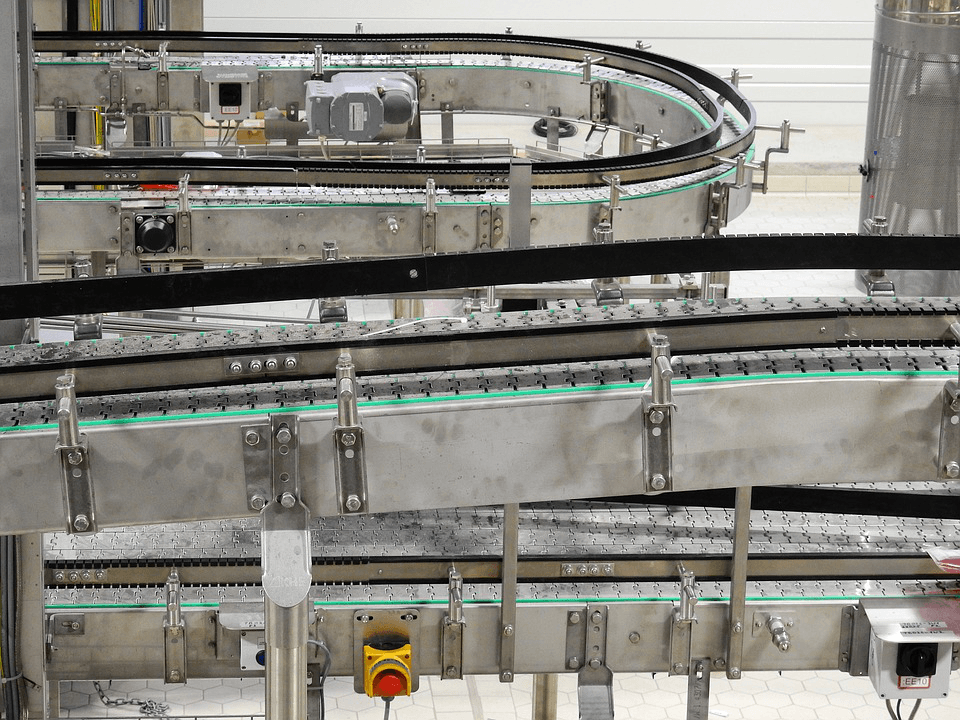 A conveyor belt in a factory with a yellow light on it