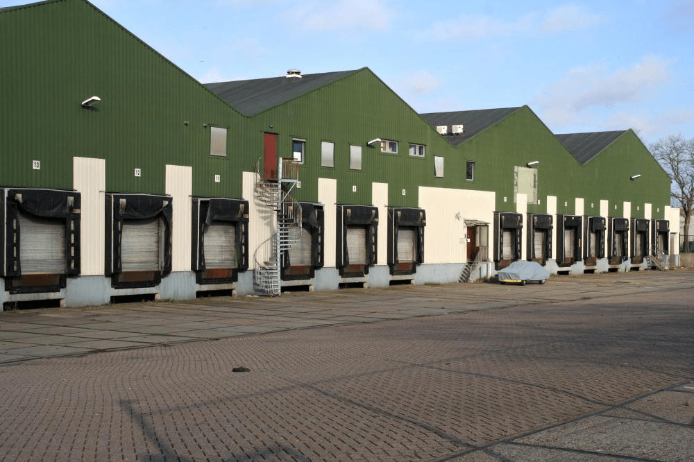 A row of green and white warehouses with loading docks