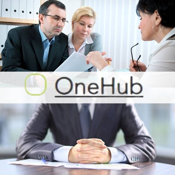 A man in a suit sits at a table with two women and the onehub logo