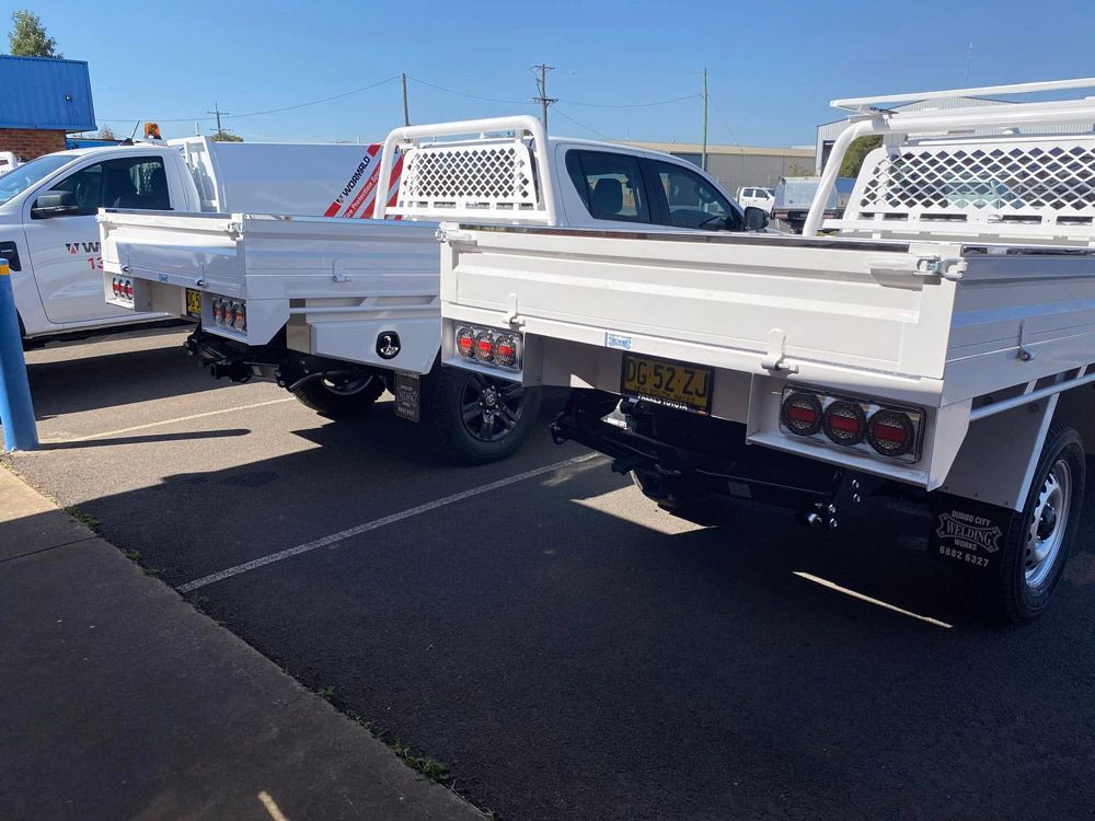 Parked Utes With Custom-Designed Trays — Welding Works in Dubbo, NSW