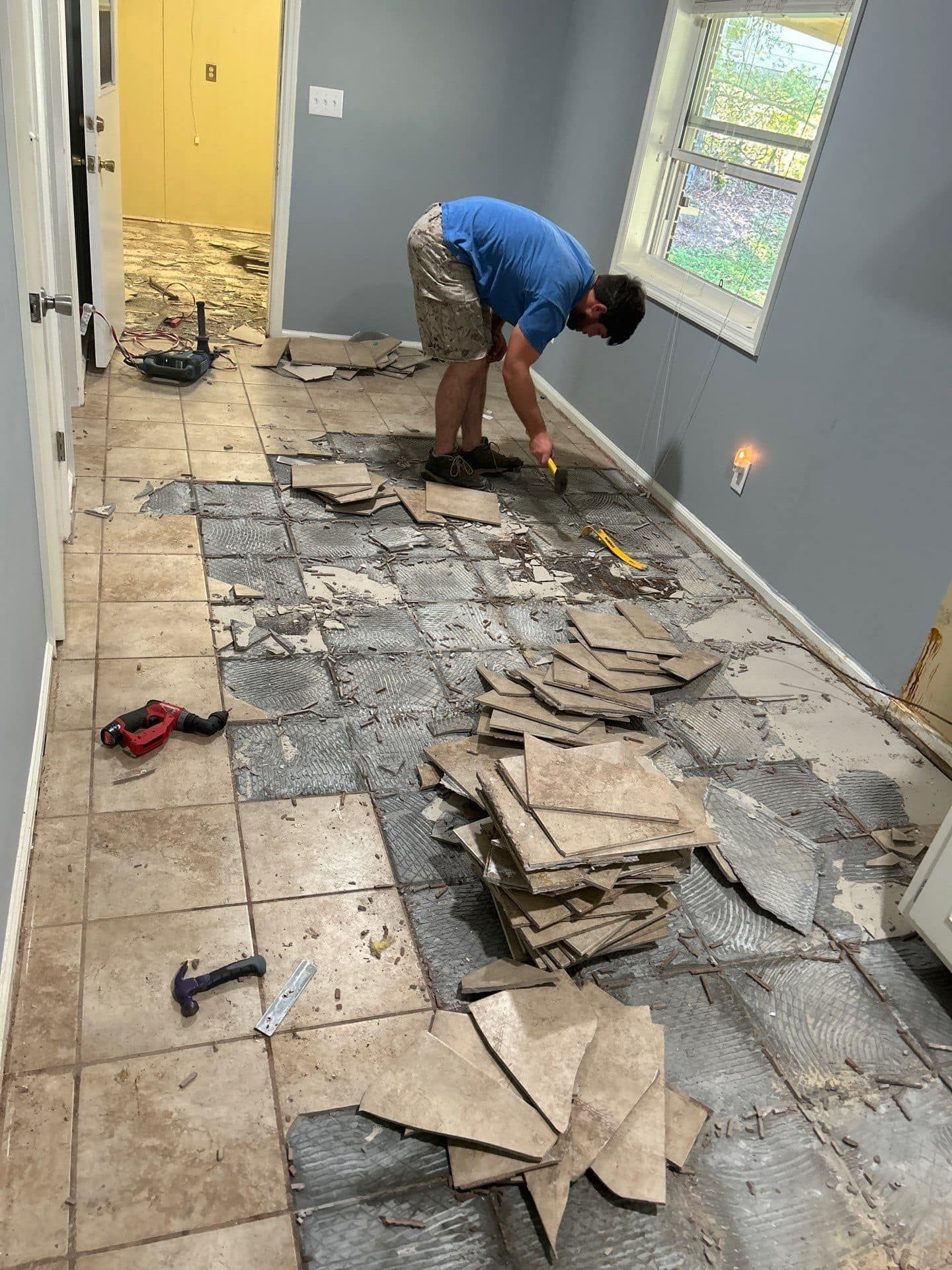 Man Removing the Old Tiles – Columbus, GA – All Veteran Renovators