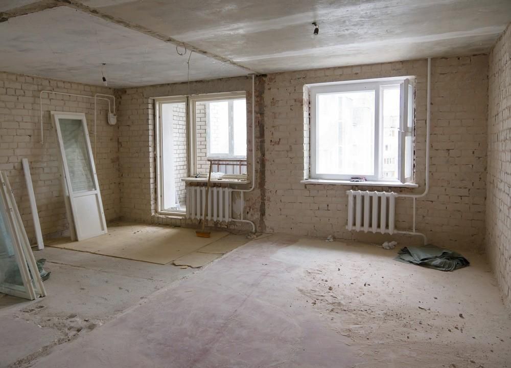 An empty room with brick walls and a radiator.