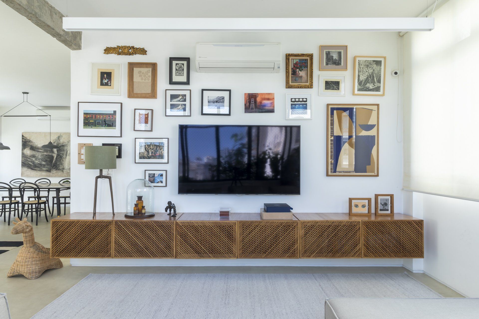 Uma sala com uma parede cheia de fotos e uma TV de tela plana.