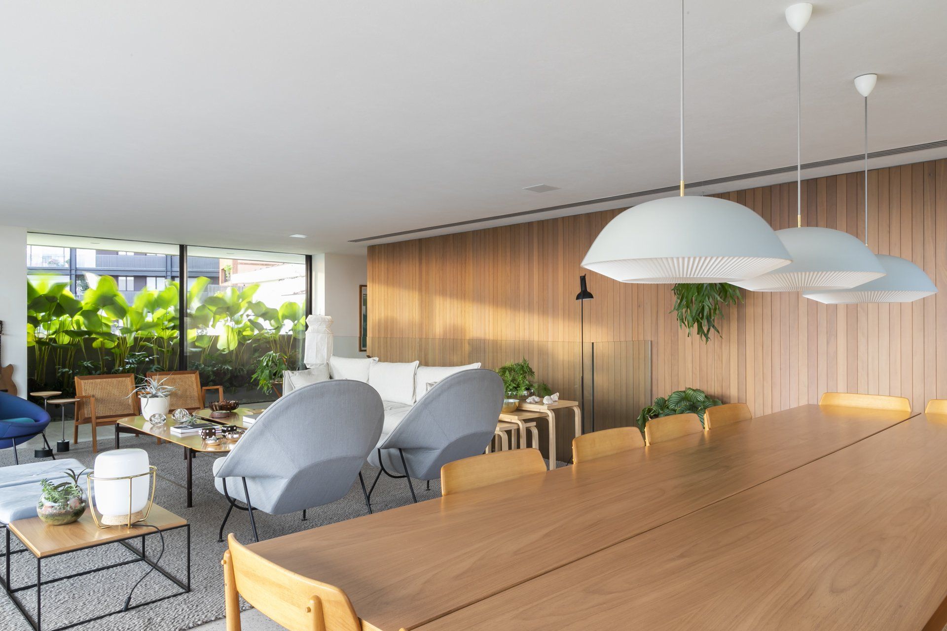 Há uma longa mesa de madeira no meio da sala.