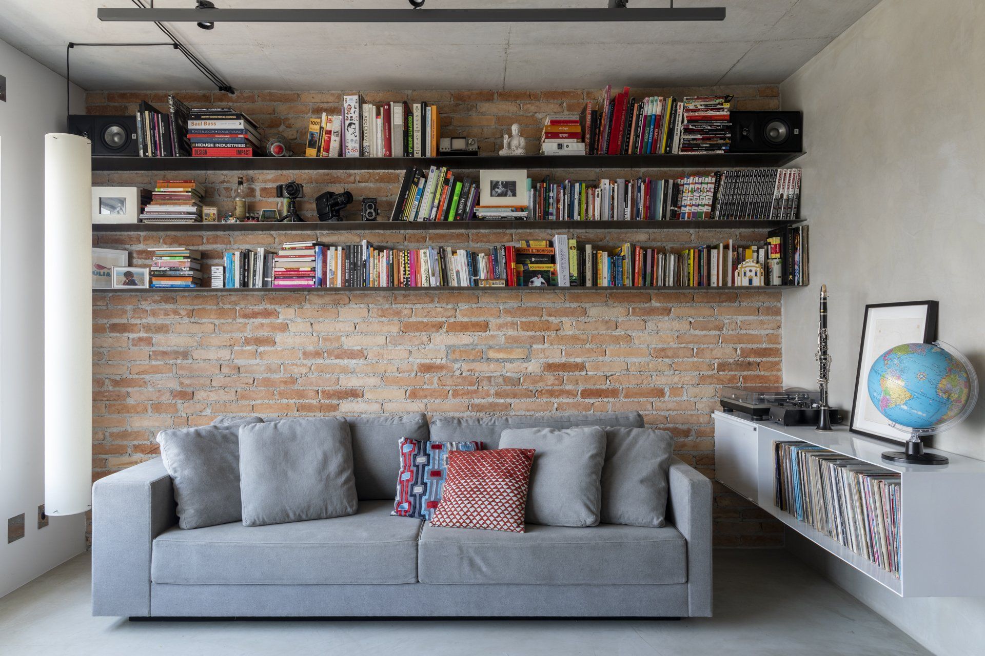 Uma sala com sofá e estantes cheias de livros.