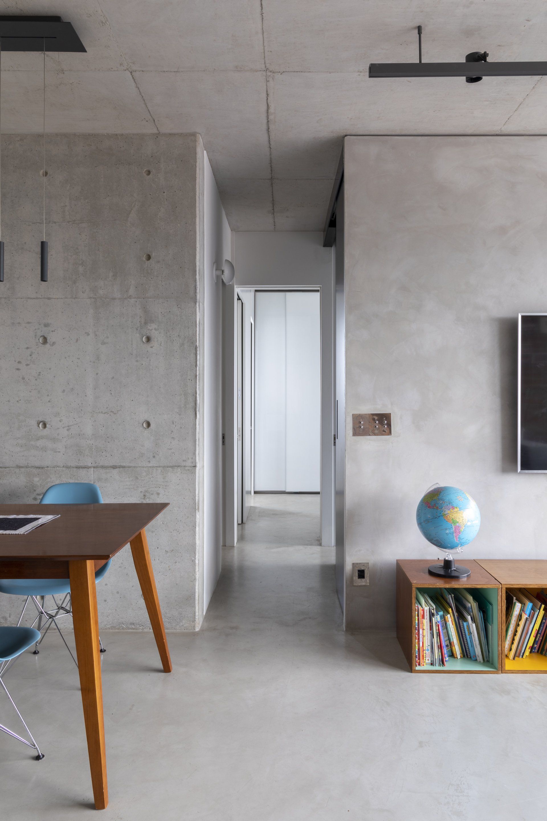 Uma sala de estar com mesa e cadeiras e um globo numa prateleira.