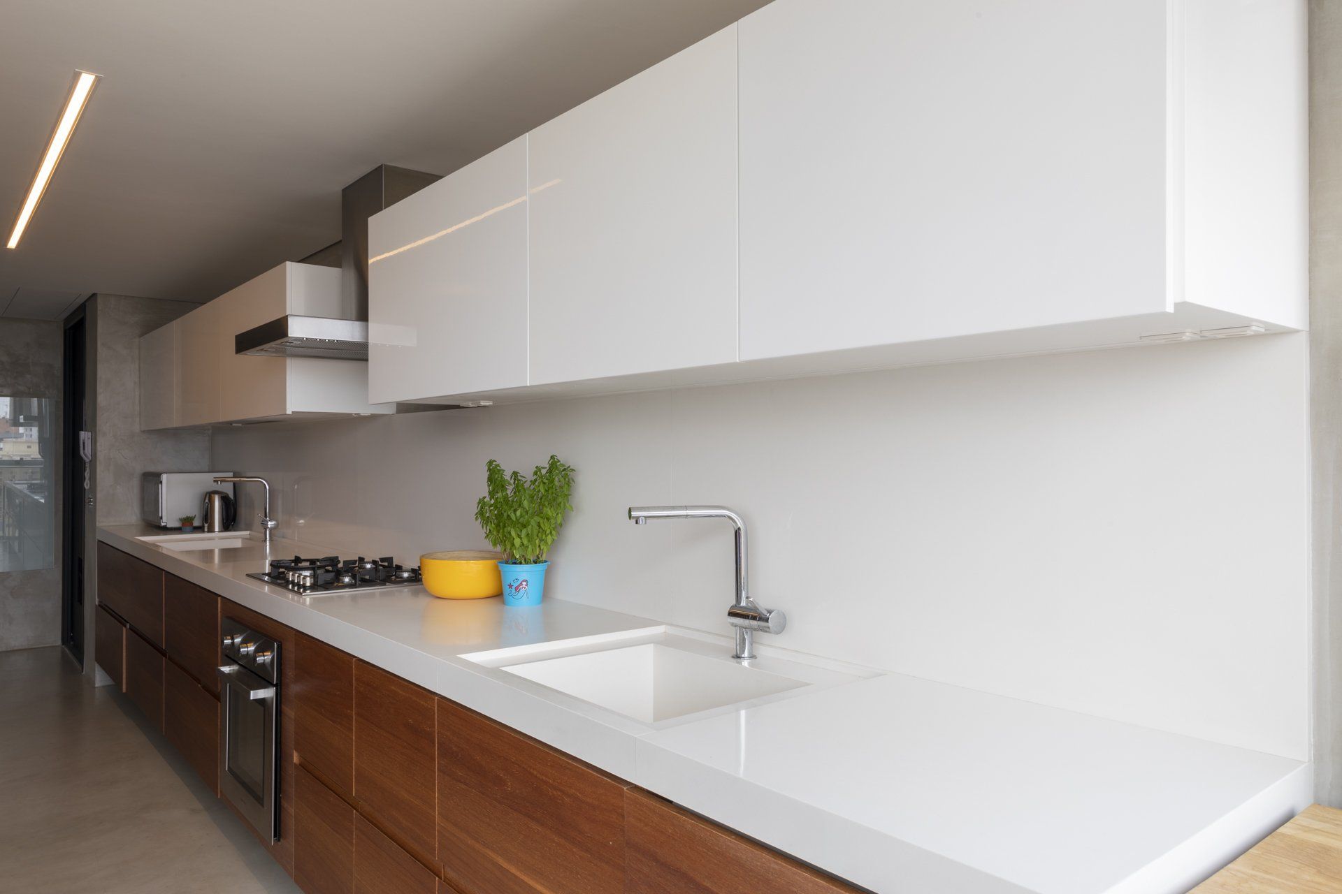 Uma cozinha com armários brancos e armários de madeira e pia