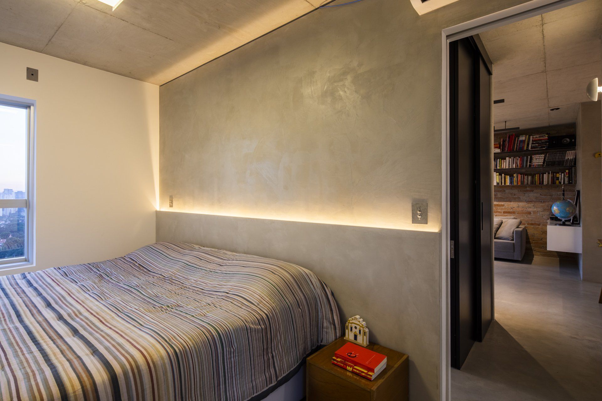 Um quarto com uma cama e uma mesa de cabeceira com um livro