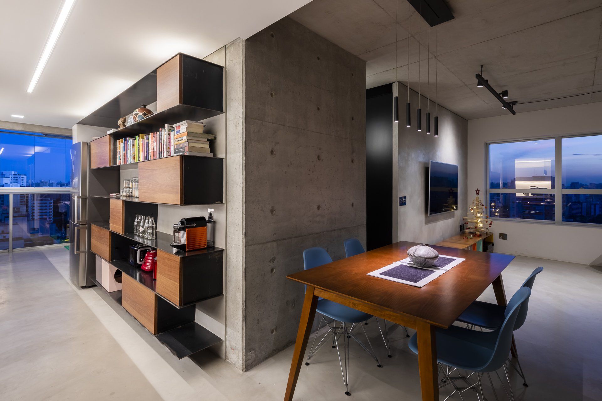 Uma sala de estar com mesa e cadeiras e uma estante