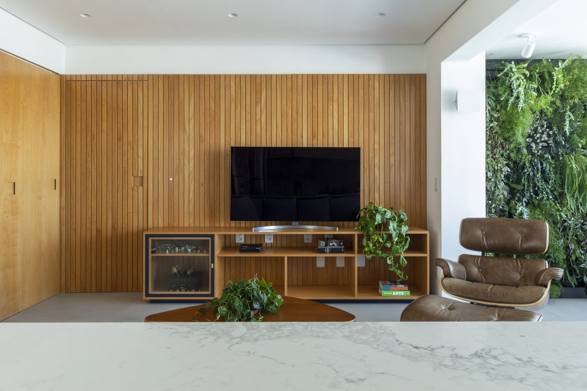 Uma sala de estar com parede de madeira e TV de tela plana.