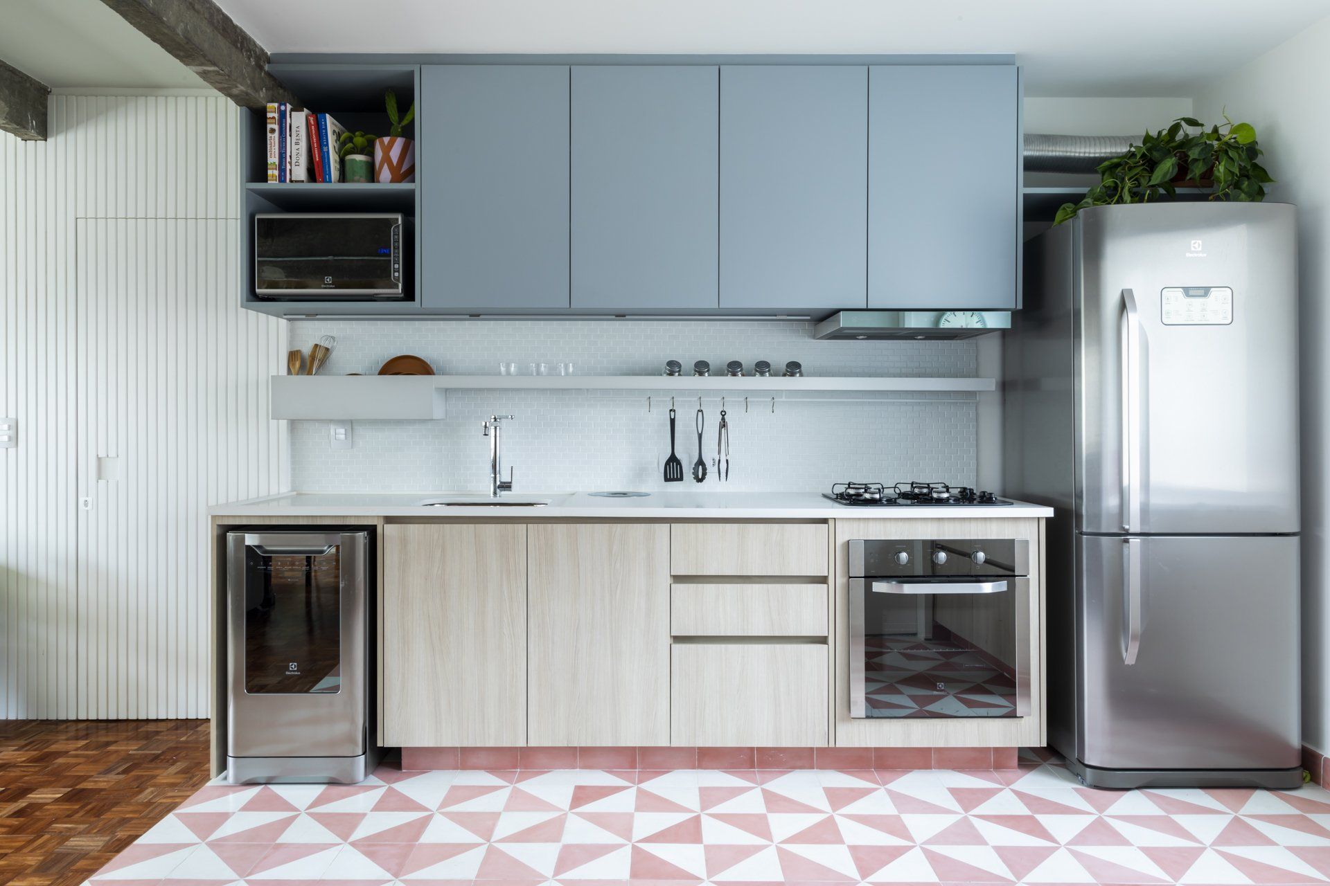 Cozinha com eletrodomésticos de aço inox, armários de madeira, fogão e geladeira.