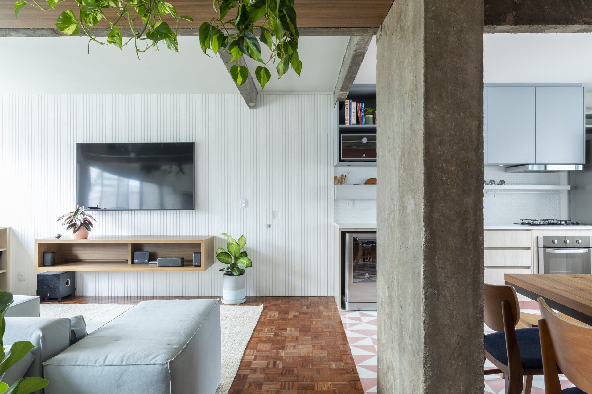 Uma sala de estar com sofá e TV de tela plana na parede.