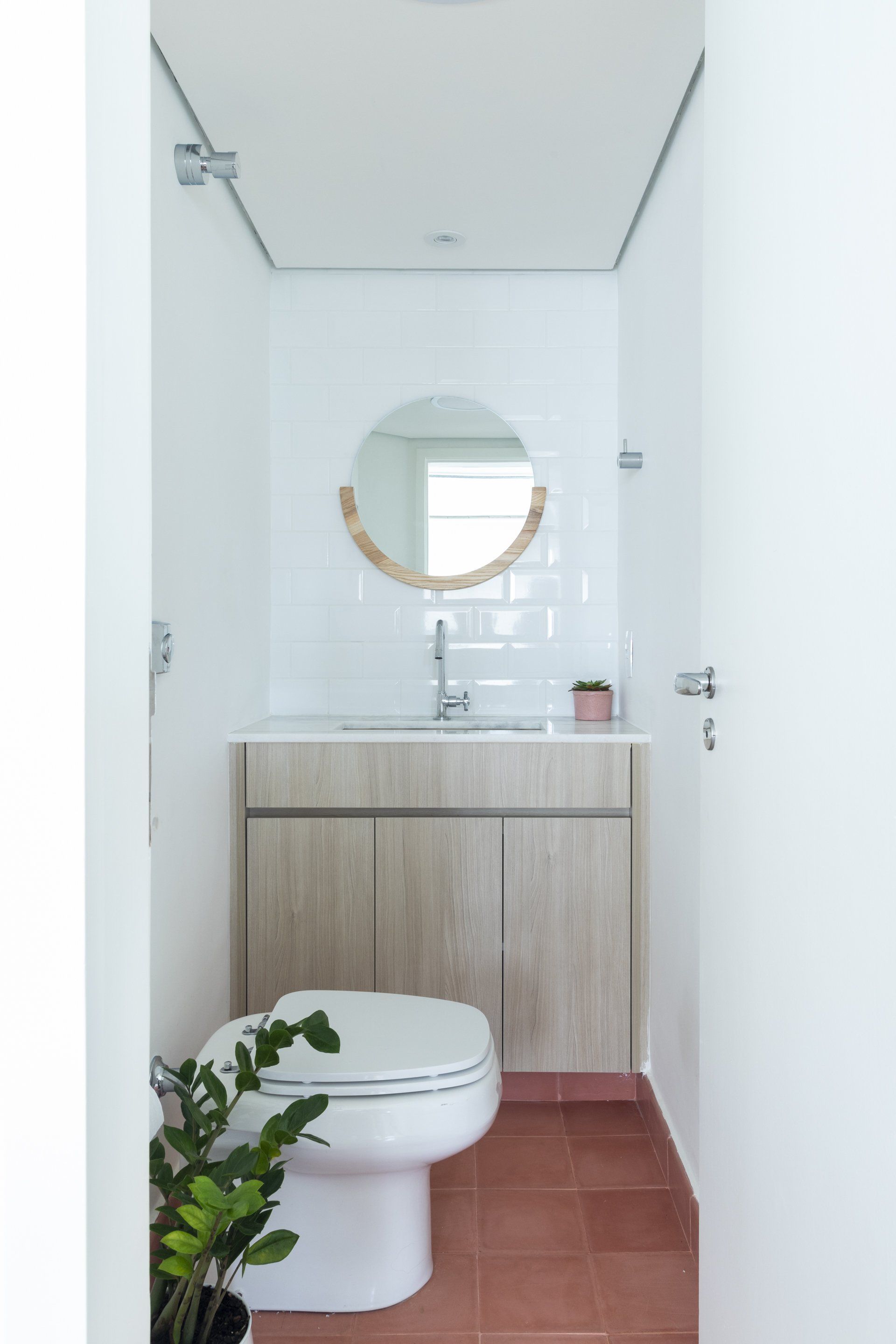 Um banheiro com vaso sanitário, pia e espelho.