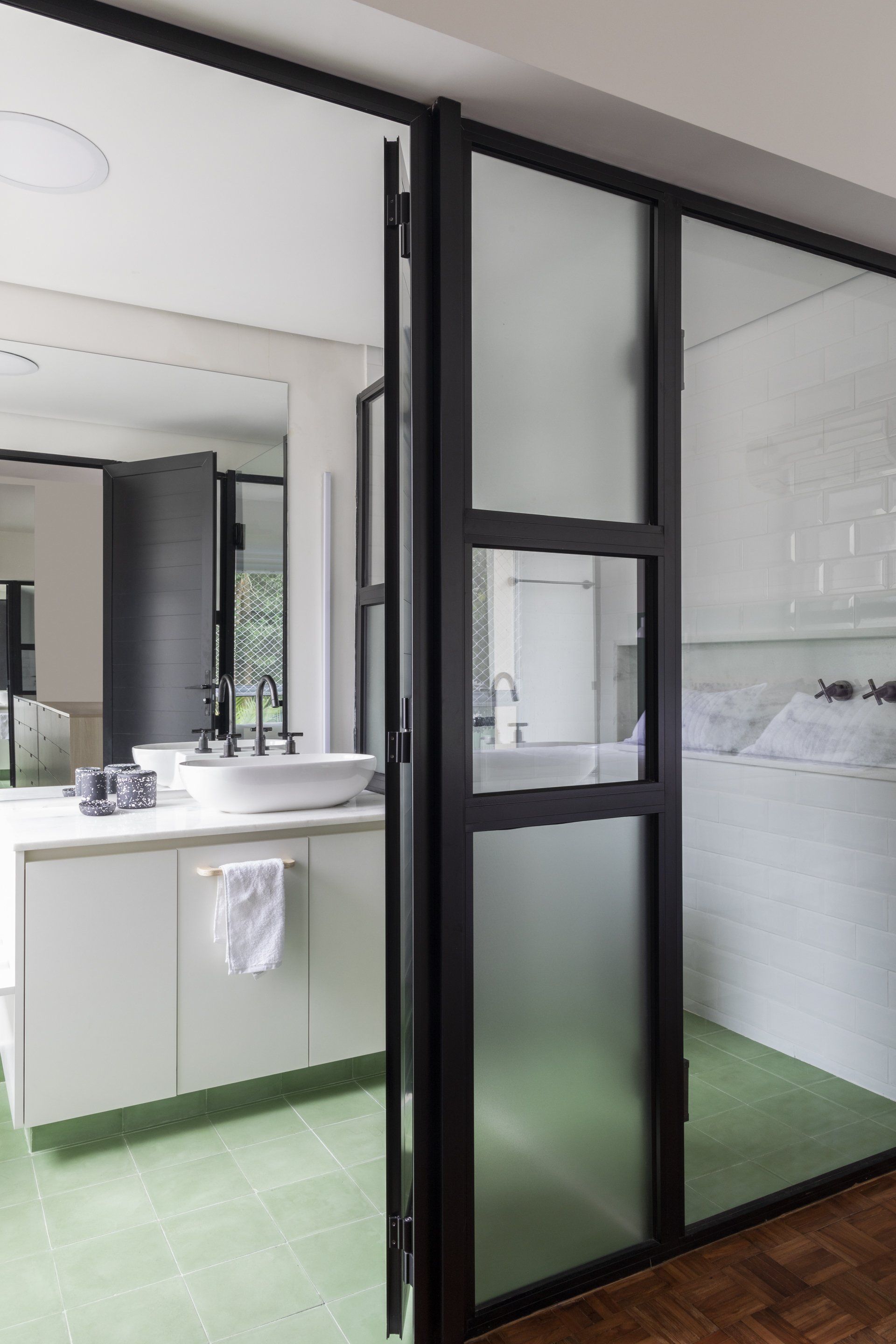 Uma casa de banho com porta de vidro deslizante entre o quarto e a casa de banho.